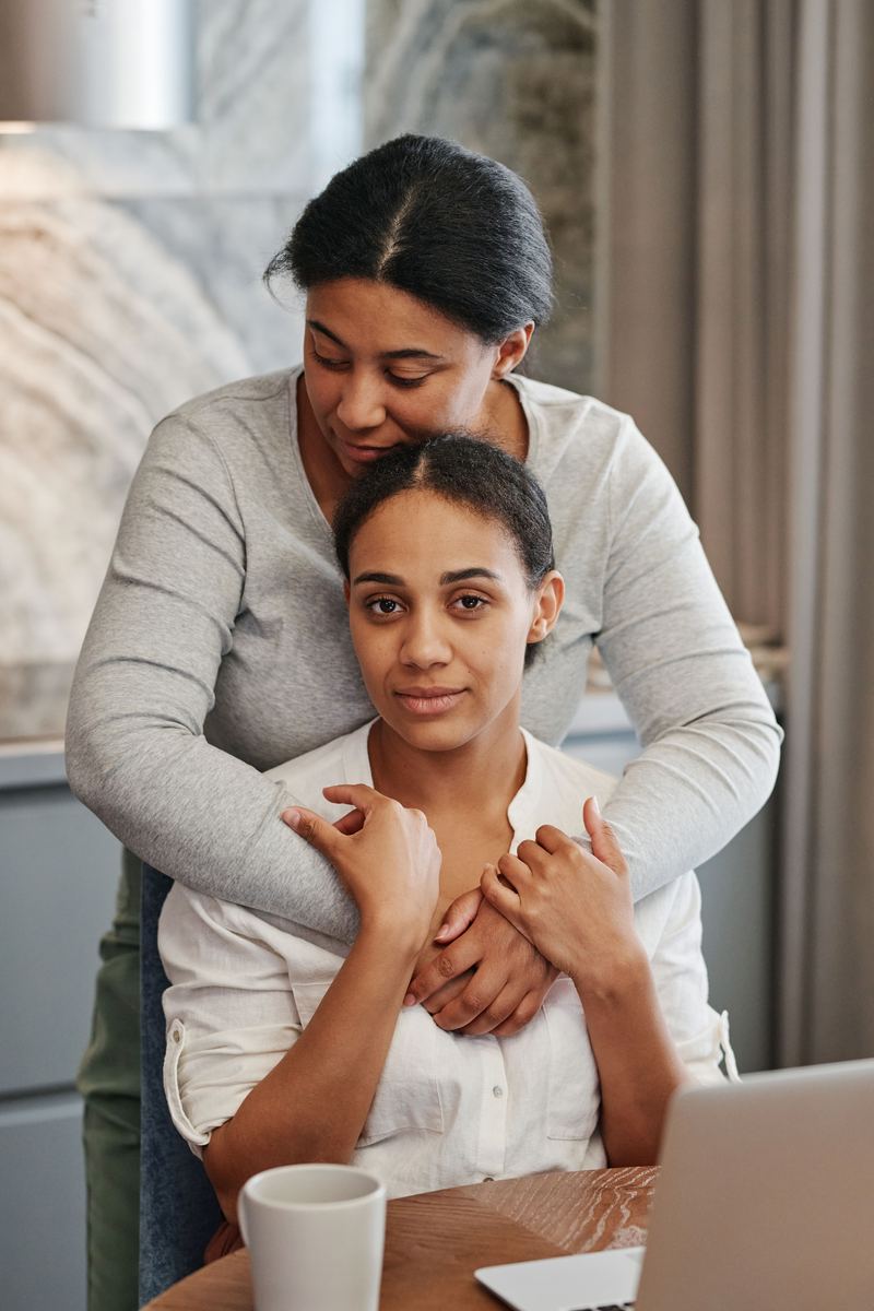 One woman comforting another with a hand on her shoulder